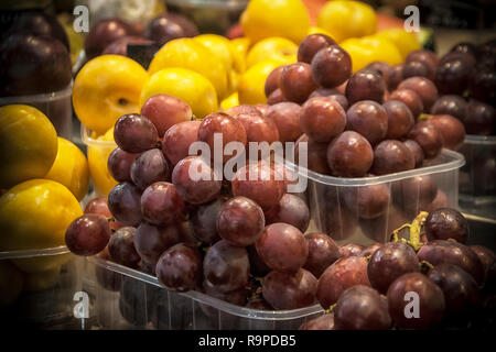Kunststoffkästen mit roten Trauben und anderen Früchten auf einem Marktplatz Abschaltdruck Stockfoto