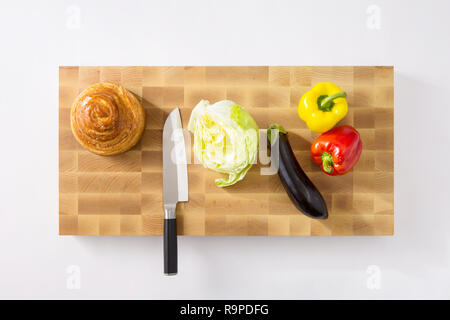 Ein schneidebrett und ein Messer. Brot, Paprika, Gurken, Auberginen, Salat. Stockfoto