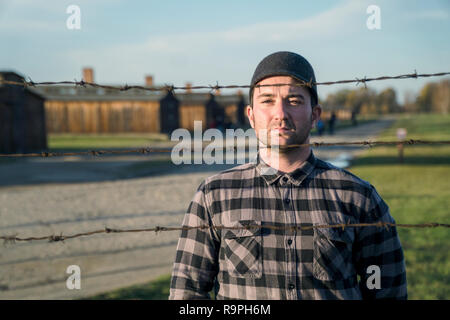 Gefangener Blick hinter Stacheldraht zaun im KZ Auschwitz, Polen Stockfoto