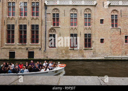 Touristische Bootsfahrt auf dem Kanal Groenerei in Brügge, Belgien. Stockfoto