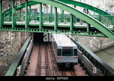 U-Bahn kommt aus einem Tunnel und geht unter Zollamtssteg Brücke während der River Crossing in Wien, Österreich. Stockfoto