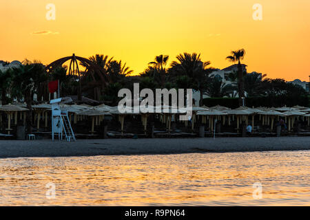 Sonnenuntergang über dem Roten Meer Palme silhuettes Hotel in Makadi Bay Ägypten. Stockfoto