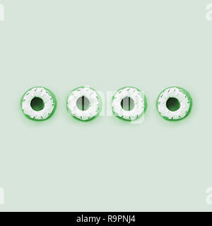 Viele kleine Kunststoff donuts liegt auf einem pastel farbigen Hintergrund. Flach minimal Muster. Ansicht von oben. Stockfoto