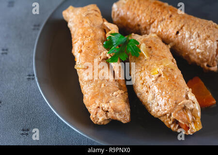 Rouladen Schweinefleisch mit Speck, Karotten, Gurken und Zwiebeln auf dem Teller serviert. Stockfoto