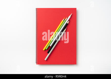 Designkonzept - Blick von oben auf die rote Spirale Notebook und viele Bleistifte auf Hintergrund für Mockup isoliert Stockfoto