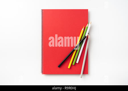 Designkonzept - Blick von oben auf die rote Spirale Notebook und viele Bleistifte auf Hintergrund für Mockup isoliert Stockfoto