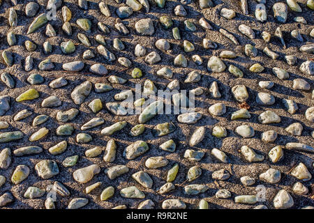 Verschiedene Steine in Beton stecken Stockfoto