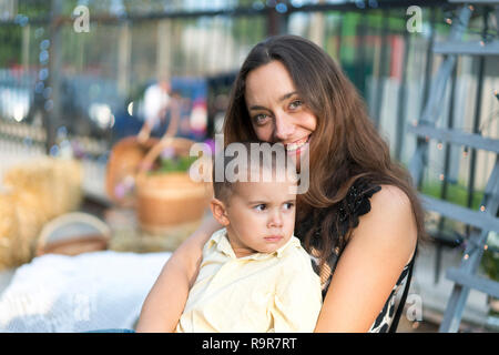 Mama hält ein Kind auf dem Arm. Eine glückliche Familie. Junge Mutter ihr Baby in die Arme und streichelte Kind meiner Mutter litso. Portret Mutter und littl Stockfoto