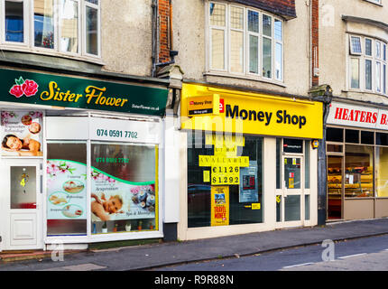 Läden von Schwester Blume, ein Massagezentrum, und das Geld, Shop, eine Wechselstube und Pfandleiher in einer Reihe von Geschäften in Woking, Surrey Stockfoto