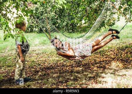 Mädchen lachen im Garten Hängematte Stockfoto