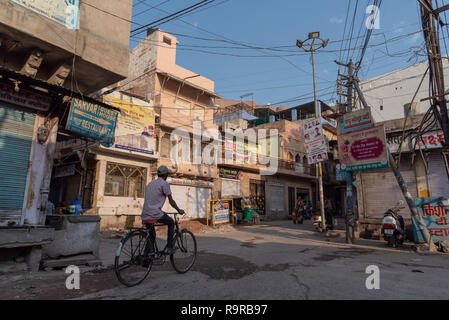 Am frühen Morgen Straßenszene in Jodhpur mit Mann auf dem Fahrrad und Überlandleitungen, Rajasthan, Indien Stockfoto