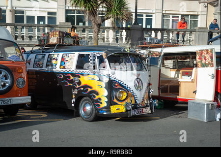 Eine benutzerdefinierte lackiert Split - screen​ Volkswagen VW Wohnmobil mit gelben Flammen auf Madeira Drive in Brighton, Sussex, England geparkt. Stockfoto