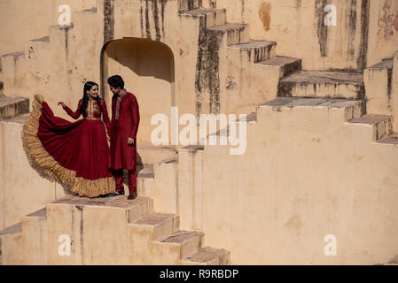 Ein paar junge, lächelnde Brautpaar aus Kalkutta für Hochzeitsfotos im Panna Meena ka Kund Schritt gut, Amer, Jaipur, Rajasthan, Indien Stockfoto