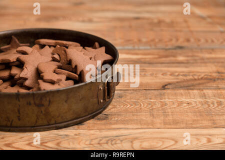 Weihnachten Lebkuchen Kuchen in Form von Sternen in springform Schüssel auf rustikalen hölzernen Tisch versammelt. Stockfoto