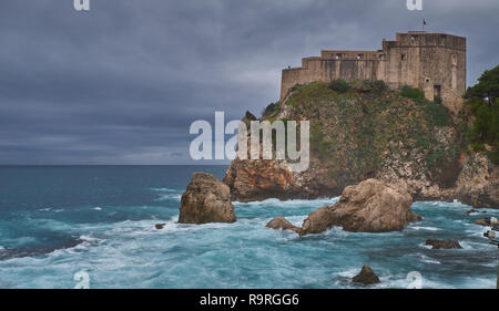 Fort Lovrijenac in Dubrovnic als vom Strand an einem stürmischen Tag gesehen, mit Wellenrauschen und Dark Cloud Horizont Stockfoto