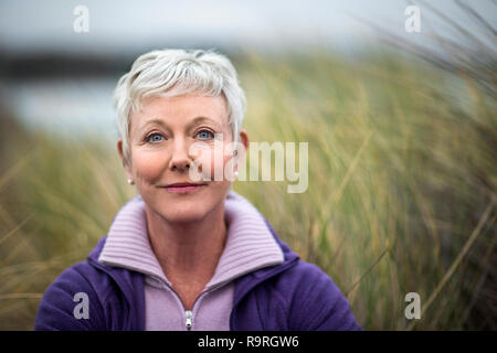 Portrait von eine attraktive reife Frau am Strand im Winter. Stockfoto