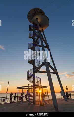 Bournemouth, Dorset, Großbritannien. 27 Dez, 2018. Schönen Sonnenuntergang über Bournemouth Strand am Ende einer schönen sonnigen Tag, wie die Besucher der Seebrücke und Strand die Sonne zu beobachten. Die spiralförmige Struktur der Zipline zipwire Startturm am Pier von Bournemouth Silhouette mit Sunburst. Credit: Carolyn Jenkins/Alamy leben Nachrichten Stockfoto