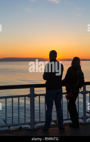 Bournemouth, Dorset, Großbritannien. 27 Dez, 2018. Schönen Sonnenuntergang über Bournemouth Strand am Ende einer schönen sonnigen Tag, wie die Besucher der Seebrücke und Strand die Sonne zu beobachten. Paar. Credit: Carolyn Jenkins/Alamy leben Nachrichten Stockfoto