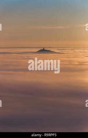 Glastonbury, Somerset. 27. Dezember 2018. UK Wetter: starker Nebel sammelt sich in die Landschaft und das Hochwasser in der Umgebung des berühmten Glastonbury Tor schaffen eine Insel über dem Nebel. Kalte Temperaturen, Feuchtigkeit und Dampf in der Nähe der Boden in diesem unglaublichen Wetterphänomen, die auch als "cloud Inversion" Credit: Wayne Farrell/Alamy Nachrichten Stockfoto