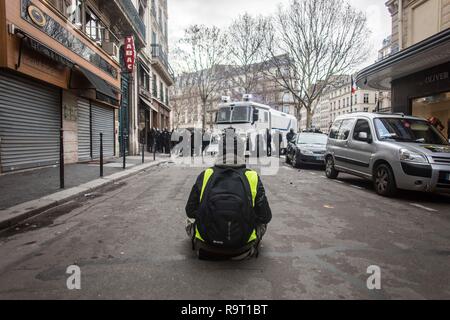 Eine gelbe Westen demonstrant gesehen Sitzecke vor dem Wassertank während der Demonstration. Gelbe weste Demonstranten gingen aus auf die Straßen von Paris ein weiteres Samstag auf, wie Sie es nannten, der Akt VI gegen den französischen Präsidenten Emmanuel Längestrich. Stockfoto