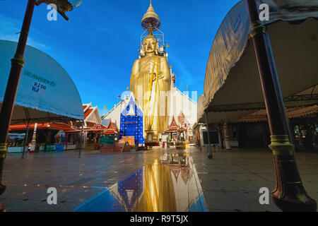 Die riesige stehende Buddha von Wat Indraviharn (Intharaviharn) in Bangkok, Thailand, die Abbildung spiegelt sich auf der glänzenden Oberfläche vor Stockfoto