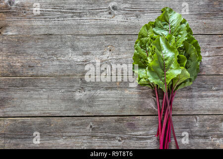 Frische Blätter von Rüben, grünes Gemüse auf lokalen Bauernmarkt, frisch geernteten Zuckerrüben Blatt Bündel auf Holz- Hintergrund Stockfoto