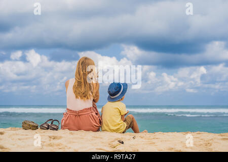 Mutter und Sohn Reisende auf erstaunliche Melasti Strand mit türkisblauen Wasser, Insel Bali Indonesien. Mit Kindern unterwegs Konzept Stockfoto