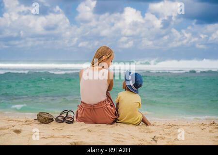 Mutter und Sohn Reisende auf erstaunliche Melasti Strand mit türkisblauen Wasser, Insel Bali Indonesien. Mit Kindern unterwegs Konzept Stockfoto