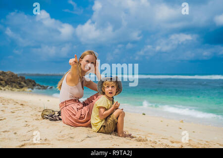 Mutter und Sohn Reisende auf erstaunliche Melasti Strand mit türkisblauen Wasser, Insel Bali Indonesien. Mit Kindern unterwegs Konzept Stockfoto