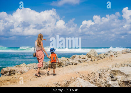 Mutter und Sohn Reisende auf erstaunliche Melasti Strand mit türkisblauen Wasser, Insel Bali Indonesien. Mit Kindern unterwegs Konzept Stockfoto