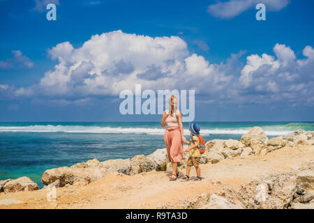 Mutter und Sohn Reisende auf erstaunliche Melasti Strand mit türkisblauen Wasser, Insel Bali Indonesien. Mit Kindern unterwegs Konzept Stockfoto