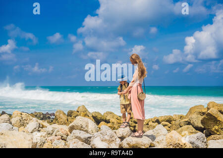 Mutter und Sohn Reisende auf erstaunliche Melasti Strand mit türkisblauen Wasser, Insel Bali Indonesien. Mit Kindern unterwegs Konzept Stockfoto