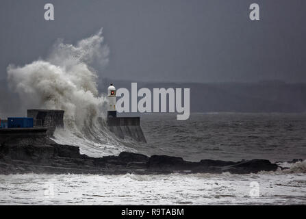 Wetter BILD WALES dargestellt: Wellen gegen die Promenade an der Wand durch den Leuchtturm in Porthcawl, South Wales, UK. Dienstag, 18 Dezember 2018 Re: H Stockfoto