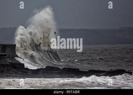 Im Bild: Wellen gegen die Promenade an der Wand durch den Leuchtturm in Porthcawl, South Wales, UK. Dienstag, 18 Dezember 2018 Re: Starker Regen ist für. Stockfoto