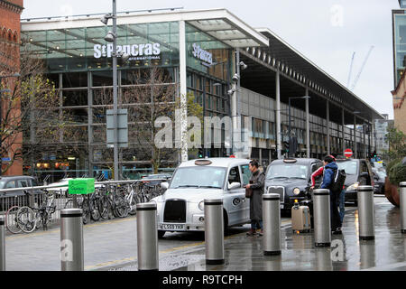 Anzeigen Passagiere mit Gepäck zahlen Taxifahrer am Bahnhof St Pancras Gebäude Pancras Straße am Kings Cross und touristische Big Bus London UK KATHY DEWITT Stockfoto