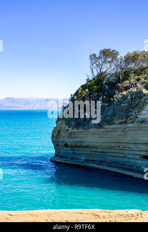 Sonnige Frühling Blick von Liebe Canal alias Canal d'Amour mit blauen Wasser des Ionischen Meeres und geschichteten Felsen auf Korfu Kerkyra Insel, Griechenland Stockfoto