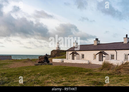 Der Pilot Cottages und Kreuz auf Ynys Llanddwyn auf Anglesey, Nordwales bei Sonnenaufgang. Stockfoto