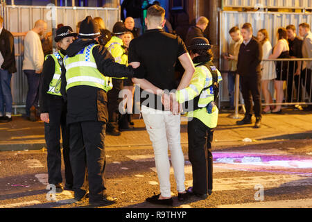 Im Bild: Ein Mann wird von der Polizei unter Arrest gestellt. Freitag, 14 Dezember 2018 Re: Nachtschwärmer in der Wind Street, Swansea, Wales, UK. Stockfoto