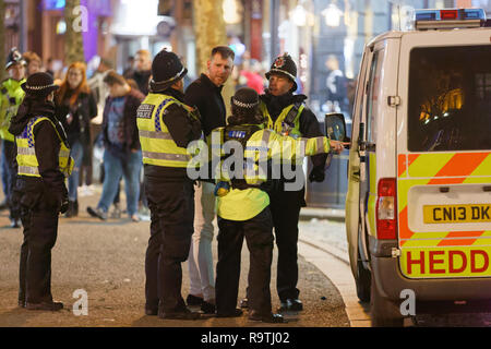 Im Bild: Ein Mann wird von der Polizei unter Arrest gestellt. Freitag, 14 Dezember 2018 Re: Nachtschwärmer in der Wind Street, Swansea, Wales, UK. Stockfoto