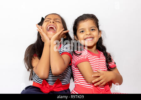 Süße Schwestern mit gestreiften Kleid lachend Stockfoto