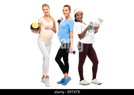 Die volle Länge der schwangeren Frauen Unterstützung gesunder Lebensstil mit Hanteln und Kugel isoliert auf weißem Stockfoto