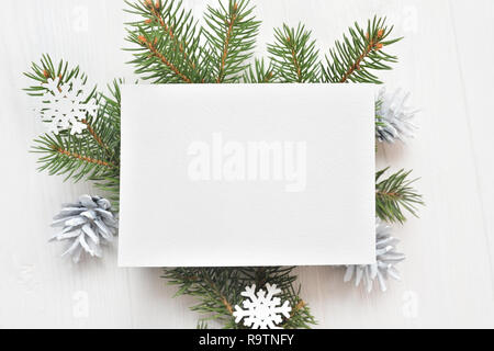 Leeres weißes Blatt Papier auf einem weißen Weihnachten Hintergrund von tannenzweigen und Kegel. Brief auf Xmas, mockup. Flach auf einem weißen Hintergrund, aus Holz mit Platz für Ihren Text. Ansicht von oben Stockfoto