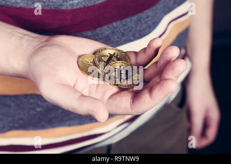 Mann hält Bitcoin btc cryptocurency Goldmünze in der Hand Stockfoto