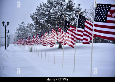 Amerikanische Fahnen säumen die Straße, an einem verschneiten Tag im Februar. Stockfoto