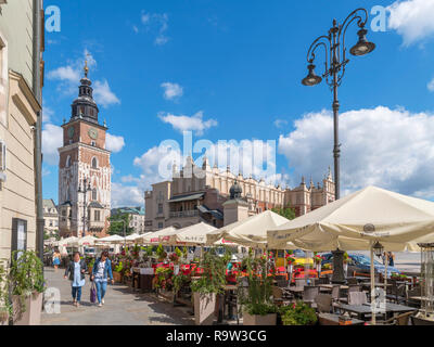 Straßencafés vor dem Rathaus turm (Wieża ratuszowa) und Tuchhallen (Sukiennice) auf dem Marktplatz (Rynek Główny), Kraków, Polen Stockfoto