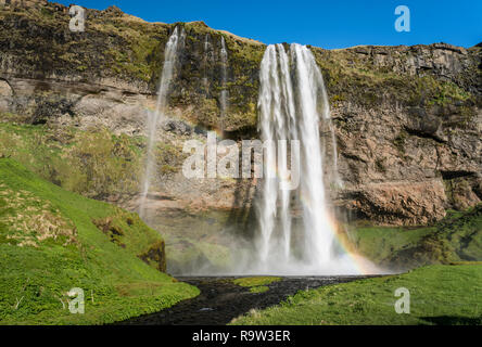 Der Wasserfall Seljalandsfoss mit Regenbogen im südlichen Island, Europa. Stockfoto