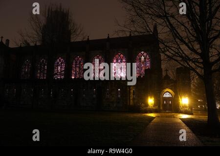 Ansicht von Außen in einer kalten, nassen Nacht der Glasfenster der Heiligen Kapelle an der Universität im Süden in Sewanee, Tennessee. Stockfoto