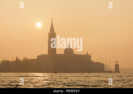 Sonnenuntergang über der Kirche von San Giorgio Maggiore (Basilika di San Giorgio Maggiore) vom italienischen Architekten Andrea Palladio entworfen und zwischen 1566 und 1610 auf der Insel San Giorgio Maggiore in der venezianischen Lagune (Laguna di Venezia) in Venedig, Italien, gebaut. Stockfoto