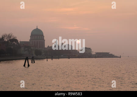 Sonnenuntergang über dem Votive Tempel (Tempio Votivo della Pace di Venezia) auf Lido (Lido di Venezia) in der venezianischen Lagune (Laguna di Venezia) in der Nähe von Venedig, Italien. Stockfoto