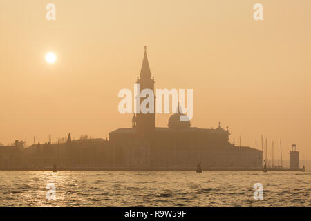 Sonnenuntergang über der Kirche von San Giorgio Maggiore (Basilika di San Giorgio Maggiore) vom italienischen Architekten Andrea Palladio entworfen und zwischen 1566 und 1610 auf der Insel San Giorgio Maggiore in der venezianischen Lagune (Laguna di Venezia) in Venedig, Italien, gebaut. Stockfoto